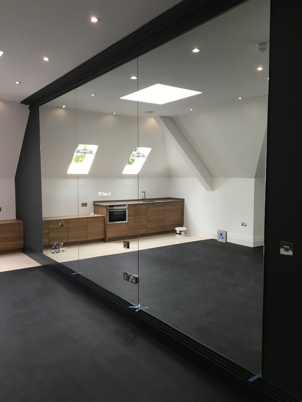Frameless glass partition in loft conversion by Ruislip glaziers